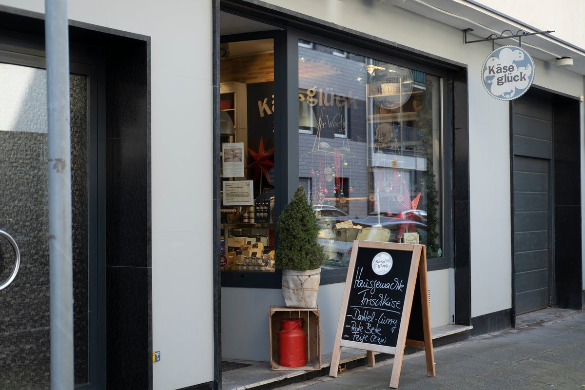 Ladenlokal von Käseglück in der Idastraße von außen, mit Schaufenster und Aufsteller