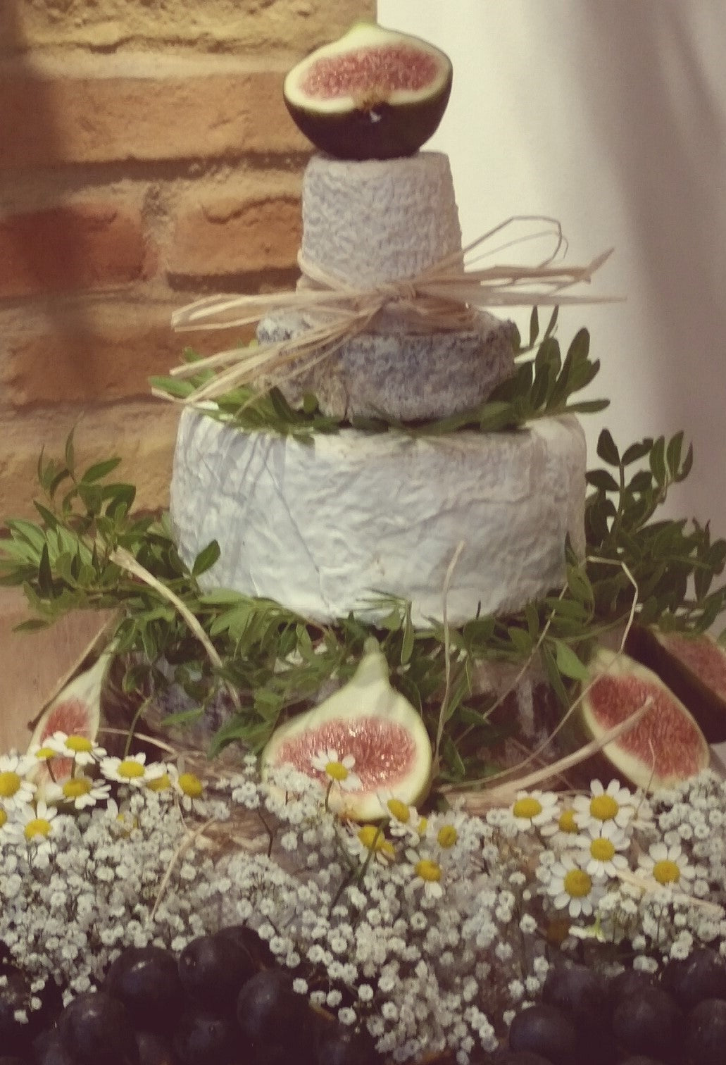 Dreistöckige Käsetorte mit Feigen, Kräutern und Blüten